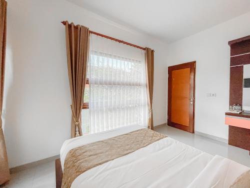 Un dormitorio con una cama y una ventana grande. en Kayangan Saba Villa, en Keramas