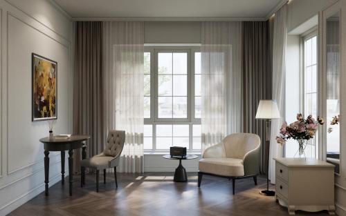 a living room with chairs and a table and a window at M Village Hotel Long Biên in Hanoi