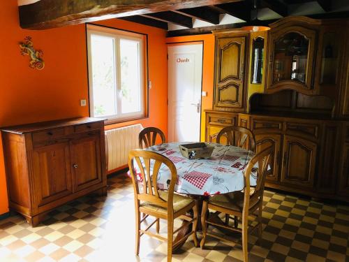 une cuisine avec une table et des chaises dans une pièce dans l'établissement Gîte de la Fontelaye, à La Fontelaye