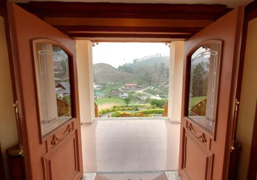 an open door with a view of a mountain at Tea county in Munnar