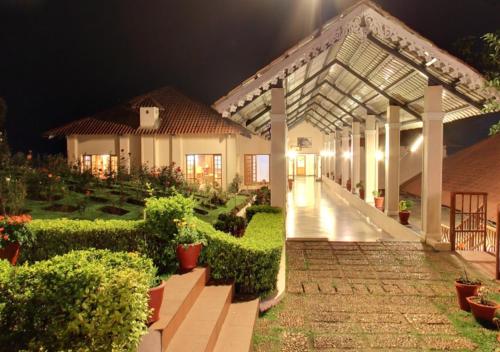 a courtyard of a house with a garden at night at Tea county in Munnar