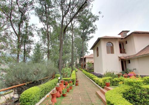 a garden in front of a house with potted plants at Tea county in Munnar