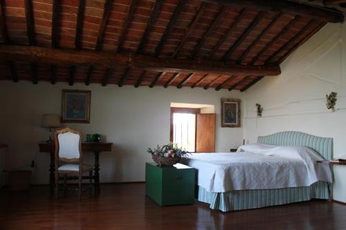 a bedroom with a bed and a chair at Torre Di Sant'Ansano in Corsano