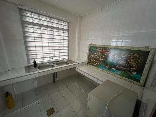 a bathroom with a sink and a painting on the wall at Destiny Guesthouse Kuching Near Airport 4pm checkout in Kuching