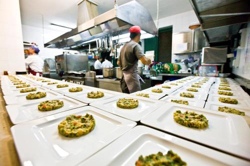 a chef preparing food in a restaurant kitchen at Hotel Pocho in San Vito lo Capo