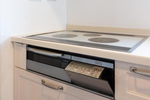 a stove top oven sitting inside of a kitchen at PanomaStays in Chofu