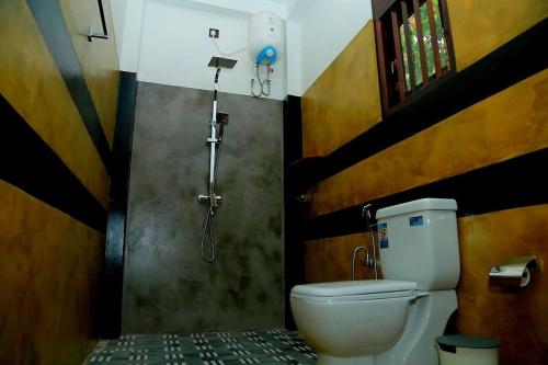 a bathroom with a shower and a toilet at Villa Koratuwa in Ahangama