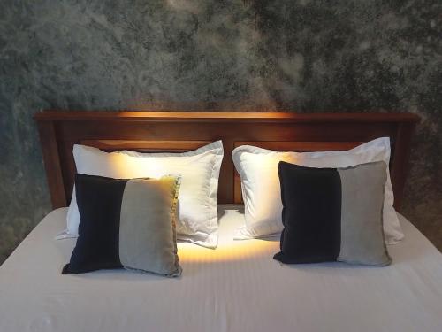 a bed with two pillows and a wooden headboard at Villa Koratuwa in Ahangama