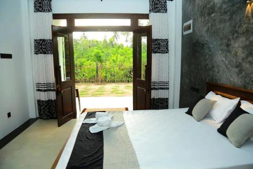 a bedroom with a bed with a door open at Villa Koratuwa in Ahangama