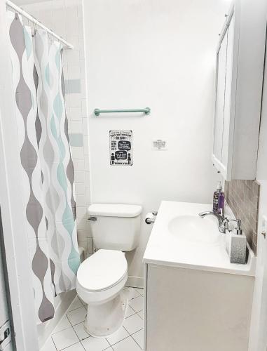 a white bathroom with a toilet and a sink at Cozy House St Johns Bluff in Jacksonville