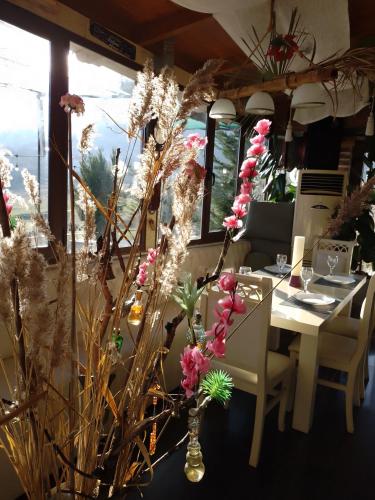 a dining room with a table and some flowers at Hotel Bar Restaurant Stone Dream in Udënisht