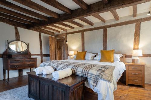 a bedroom with a large bed and a mirror at Orchard Cottage - Beautiful Home near Broadway! in Weston Subedge