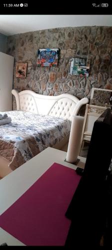 a bedroom with a bed and a desk with a laptop at Hotel Bar Restaurant Stone Dream in Udënisht