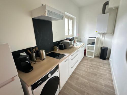 une cuisine avec des armoires blanches et un comptoir dans l'établissement Quiet T2 Downtown overlooking Saumur Castle, à Saumur