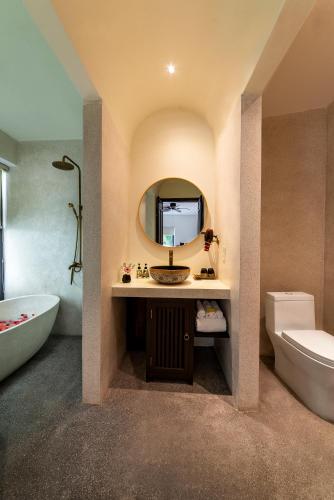 a bathroom with a sink and a tub and a toilet at Hoianoi Villa_A Little Hoi An_Entire villa in Hoi An