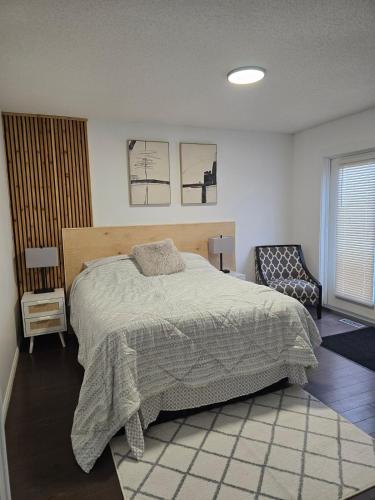 a bedroom with a large bed and a chair at Full House - Main Floor in Regina