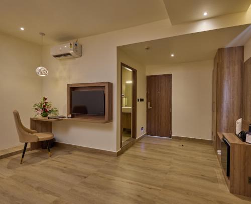 a living room with a desk and a television at Grand Continent Mysore A Sarovar Portico Affiliate Hotel in Mysore