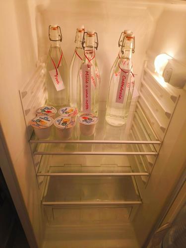 a refrigerator with two empty milk bottles in it at B&B IL POETA in Palermo