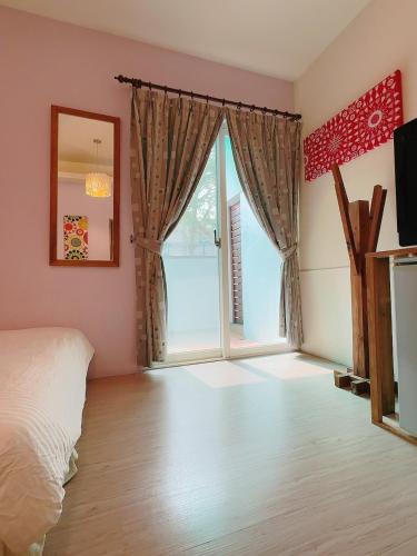 a bedroom with a bed and a sliding glass door at 17 Happiness in Xiaoliuqiu
