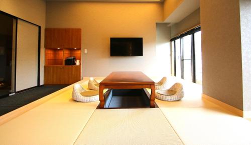 a living room with a table and two chairs at Hana No Shizuku in Ureshino