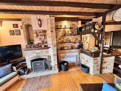 a living room with a stone fireplace and a tv at Paragon of Arachova in Arachova