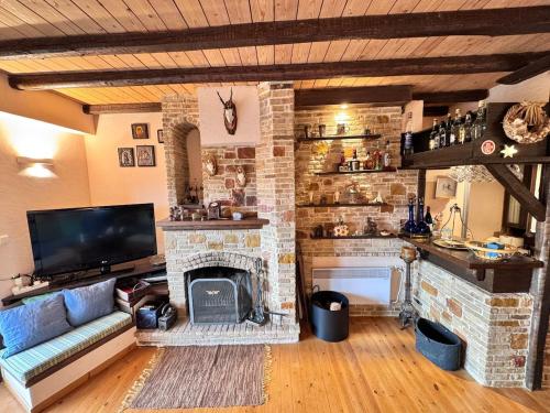 a living room with a stone fireplace and a tv at Paragon of Arachova in Arachova