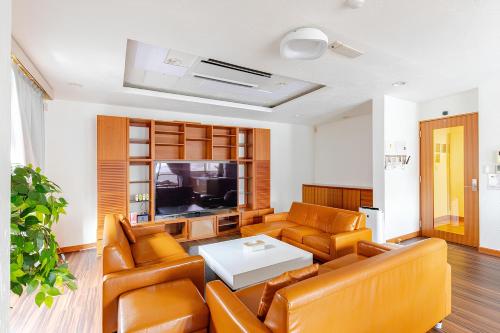 a living room with leather furniture and a tv at en stay003 in Osaka
