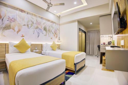 a hotel room with two beds and a kitchen at Cozzet Mahad in Mahad