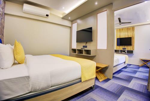 a hotel room with two beds and a tv at Cozzet Mahad in Mahad