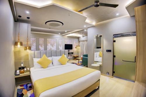 a bedroom with a large white bed with yellow pillows at Cozzet Mahad in Mahad
