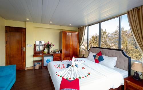 a bedroom with a large bed with a candle on it at Sapa Hidden Gem Hotel & Spa in Sa Pa