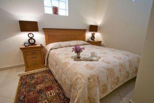 a bedroom with a bed with a table with flowers on it at Andria Suites in Andros