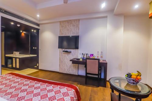 a bedroom with a bed and a table and a desk at Hotel Godwin Deluxe - Free Airport Pick-Up in New Delhi