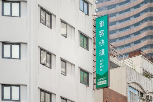 a green sign on the side of a building at CHECK inn Express Kaohsiung Love River in Kaohsiung