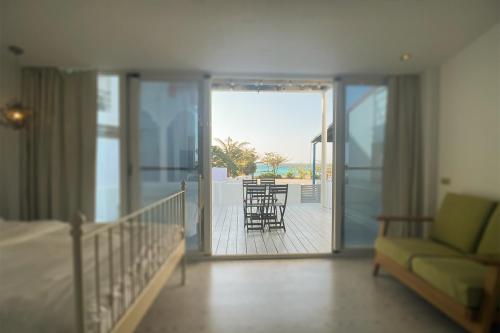 a room with a bed and a balcony with chairs at 初嶼Meet in Hengchun