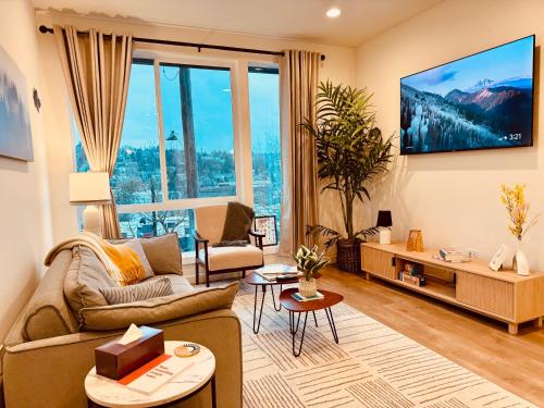 a living room with a couch and a tv at Luxe & Bright Gem - Prime Location, Roof Deck, View in Seattle