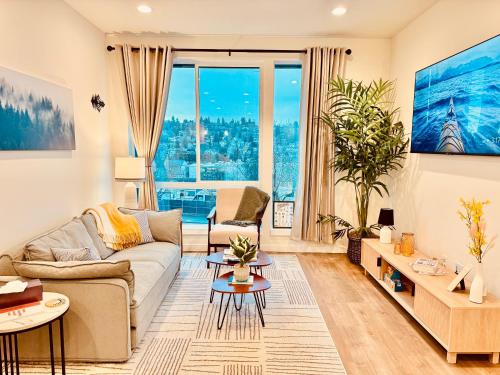 a living room with a couch and a large window at Luxe & Bright Gem - Prime Location, Roof Deck, View in Seattle