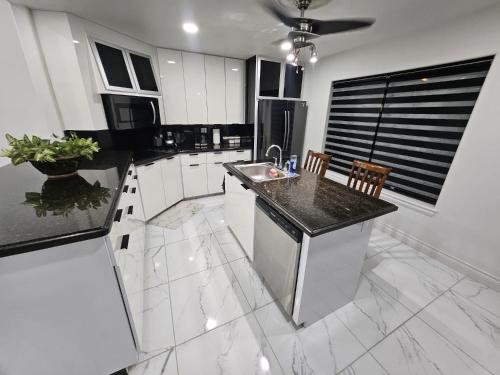 a kitchen with white cabinets and a black counter top at Family Luxury home with Pool in McAllen near by hospitals and stores in McAllen