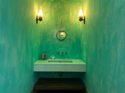 a bathroom with a sink and a green wall at 初嶼Meet in Hengchun