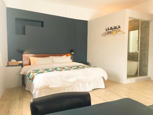 a bedroom with a bed with a blue wall at 初嶼Meet in Hengchun