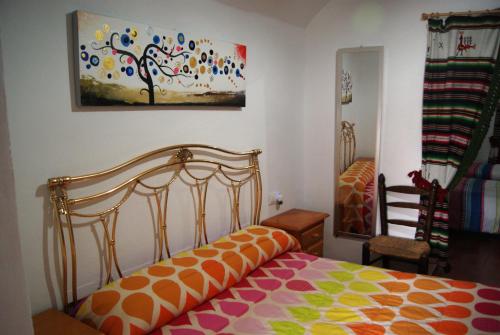 a bedroom with a bed and a painting on the wall at Cuevas de María in Guadix