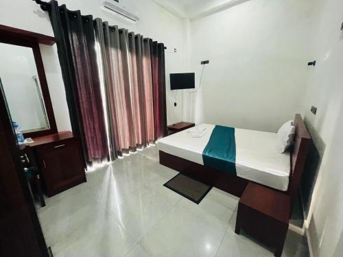 a bedroom with a bed and a television in it at Hotel Green Fall Kandyan in Ambatenna