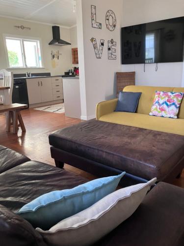 a living room with two beds and a yellow couch at City oasis in Gisborne