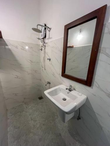 a bathroom with a sink and a mirror at Abraham Beach House in Tangalle
