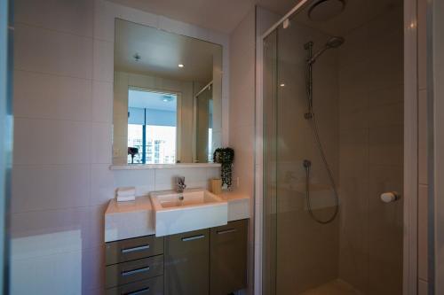 a bathroom with a sink and a shower with a mirror at Southbank 40 in Melbourne