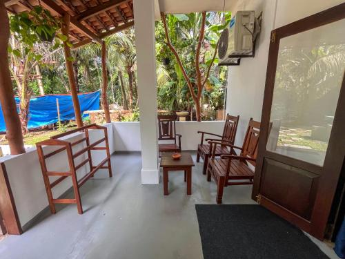 una stanza con sedie, televisore e alberi di Abraham Beach House a Tangalle