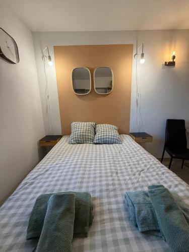 - une chambre avec un lit et deux miroirs sur le mur dans l'établissement Studio 108 Parking Gratuit, à Aix-en-Provence
