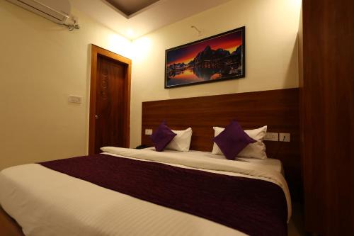 a bedroom with a large bed with purple pillows at Perfectstayz Value Forest Valley Rishikesh in Rishīkesh