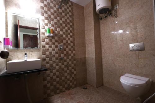 a bathroom with a toilet and a sink and a mirror at Perfectstayz Value Forest Valley Rishikesh in Rishīkesh