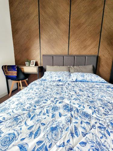a bed with a blue and white comforter on it at UKM Bangi Wonderland 3BR 2bath 2parking in Kampong Tangkas